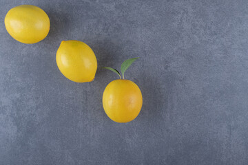 Three fresh lemon on grey background