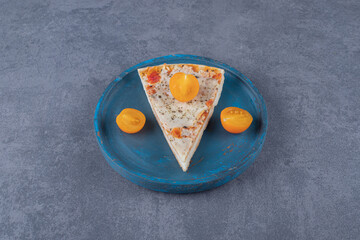 Margarita pizza slices with tomato on blue wooden plate