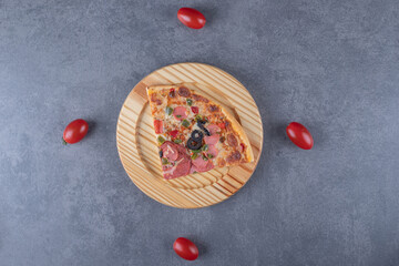 Tope view of fresh pizza slice on wooden plate