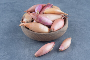 Bowl of fresh onions on blue background