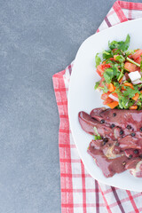 Raw meat and salad on white plate