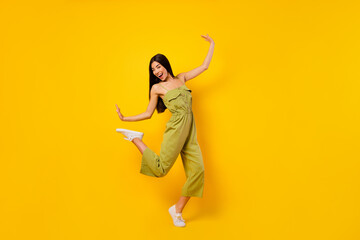 Full length photo of carefree positive girl enjoy dancing clubbing rejoice isolated on yellow color...