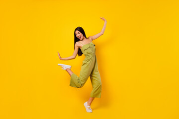 Full length photo of carefree positive girl enjoy dancing clubbing rejoice isolated on yellow color background