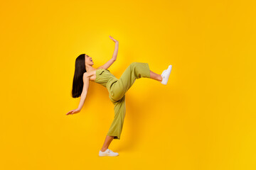 Fototapeta na wymiar Full length profile photo of positive indonesian person have good mood big step isolated on yellow color background