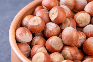 Hazelnut in wooden bowl on black background. Organic hazelnut.