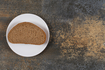 One black bread slice on white plate