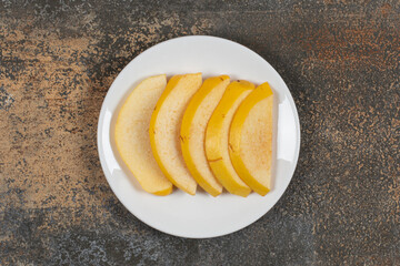 Ripe sliced quince on white plate