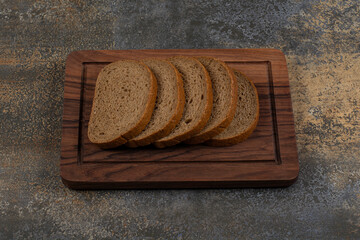 Tasty sliced black bread on wooden board