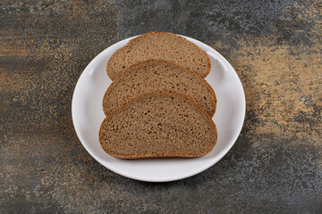 Rye black bread slices on white plate