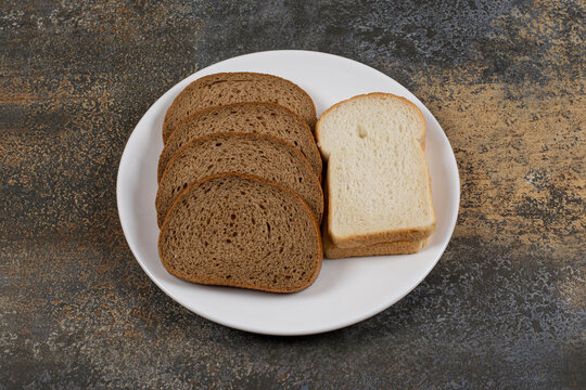 Black and white bread slices on white plate