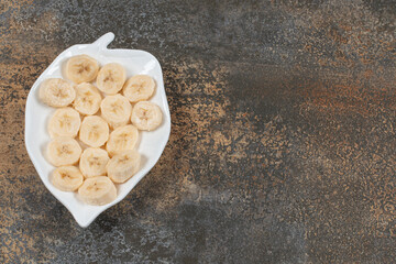 Fototapeta na wymiar Sliced peeled bananas on white plate