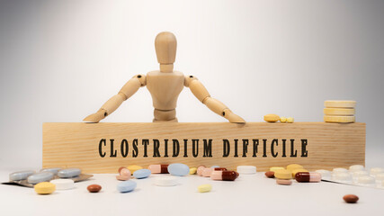 clostridium difficile disease. Written on wooden surface. On wood and medicine concept. white background. Diseases and treatments