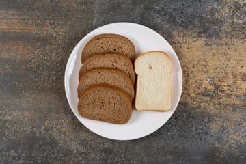 Black and white bread slices on white plate