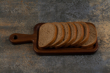 Sliced fresh black bread on wooden board