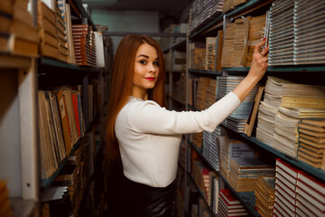Vinnytsia, Ukraine - September 15, 2022. A female student chooses a book to take an exam at the...