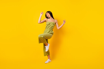 Fototapeta na wymiar Full length portrait of cheerful pretty young girl have good mood dancing isolated on yellow color background