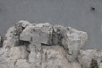 Closeup natural stones wall partially smoothly plastered