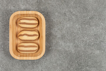 Chocolate striped biscuits on wooden plate