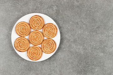 Plate of delicious round biscuits on marble background