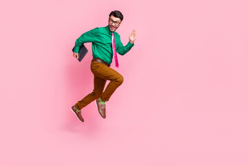 Fototapeta na wymiar Full length photo of busy hurrying man dressed green shirt eyewear jumping holding device empty space isolated pink color background