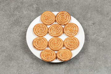 Plate of delicious round biscuits on marble background