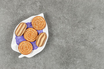 Delicious chocolate striped biscuits and sesame biscuits on white plate