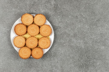 Delicious cookies filled with cream on white plate
