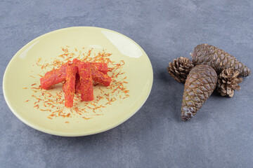 Turkish delight rahat lokum with pistachios and dry raisins on yellow plate