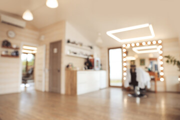 Blurred view of stylish barbershop interior with professional hairdresser's workplace