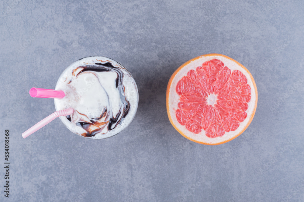 Wall mural Ripe grapefruit with Fresh milk shake on table close-up