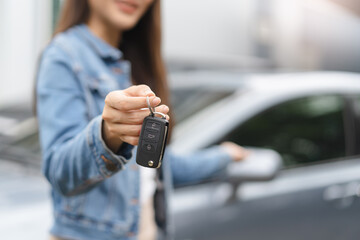 transportation rental automotive business concept. Close up hands of rental auto agent giving car remote key to client to travel sightseeing. - obrazy, fototapety, plakaty