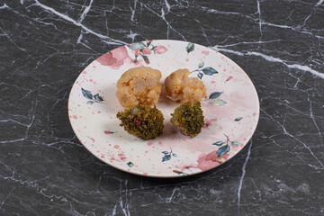 Broccoli and meat on the plate , on the marble background