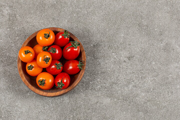 Delicious tomatoes in the bowl , on the marble background