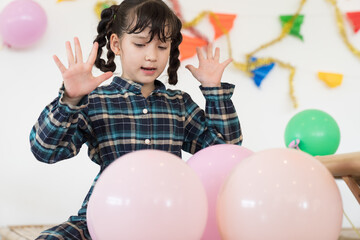 Closeup of asian child girl play with pink balloon in party at home
