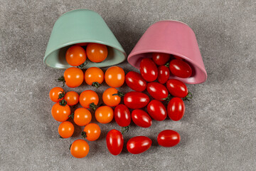Two bowls of overturned tomatoes, on the marble background