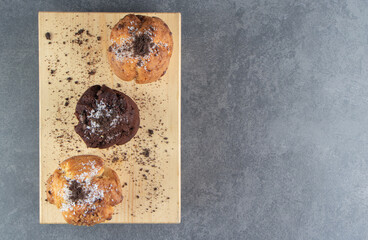 Chocolate muffin with nut muffins on a wooden board