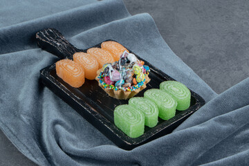 Delicious muffin with orange and green jelly candies