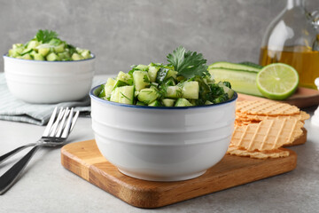 Bowl of delicious cucumber salad served on light table