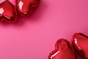 Red heart shaped balloons on pink background, flat lay with space for text. Saint Valentine's day...