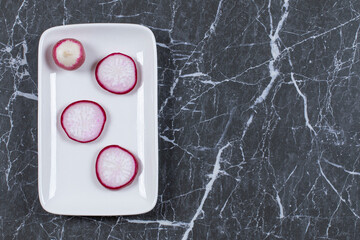 Sliced red radish on white plate