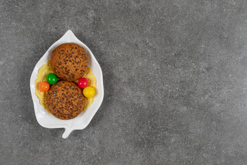 Delicious sweet cookies with candies on white plate