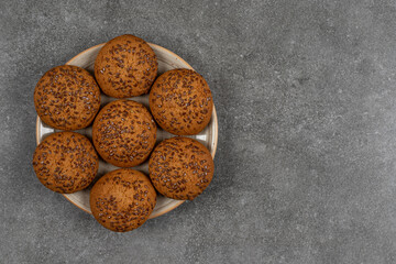 Pile of cookies with sesame seeds on wooden piece