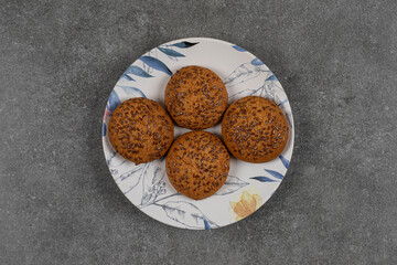Sweet cookies with sesame seeds on colorful plate