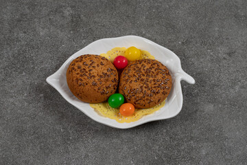 Delicious sweet cookies with candies on white plate