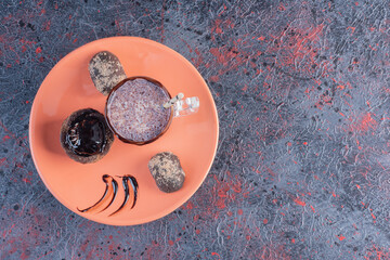 Fresh milk shake and chocolate muffin on orange plate. Top view