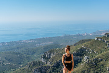 Naklejka premium Caucasian blonde woman in front of a view in the mountain looking at the side