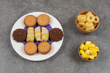 Plate of desserts and candies on marble background