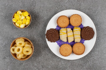 Plate of desserts and candies on marble background