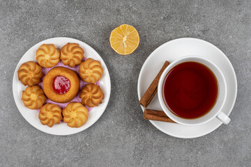 Plate of desserts and cup of tea on marble background
