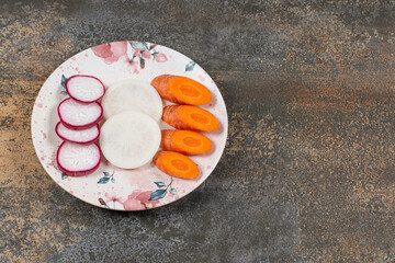 Healthy white and red radish, carrot on the plate , on the marble background
